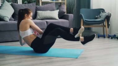 Evde yoga mat spor eğitim karın kasları yapıyor çekici kız.