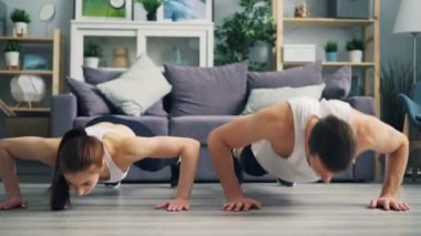 Güzel çift birlikte şınav yapıyor ve evde eller alkışlayan egzersiz