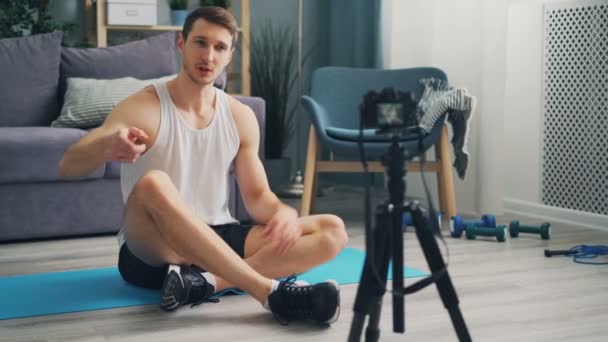 Sporty male blogger making video for blog exercising and talking using camera — Stock Video