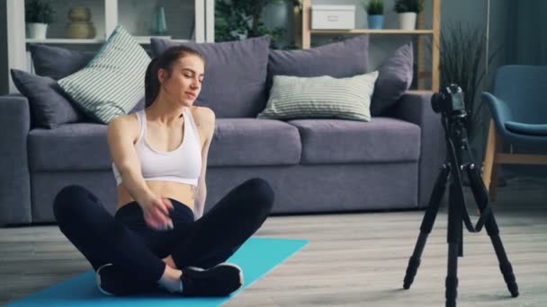 Atractiva blogger deportista grabando video con cámara haciendo ejercicio en casa — Vídeos de Stock