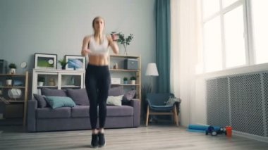 Oturma odasında çalışma dışarı ev atlama ip spor yapıyor fit kadın öğrenci