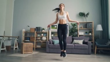 Ciddi genç kadının spor yapması evde kilo ip atlama egzersiz