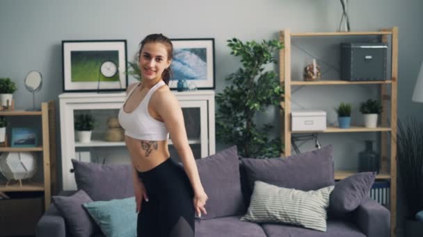 Smiling mujer culturista mirando a la cámara y el cuerpo en movimiento mostrando los músculos — Vídeos de Stock