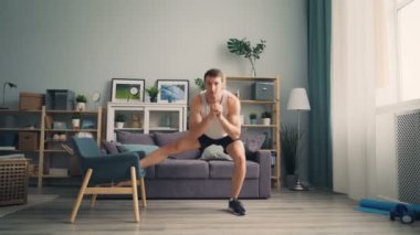 Genç adam ile koltuk yapma çömelme kapalı çalışma dışarı ev spor.