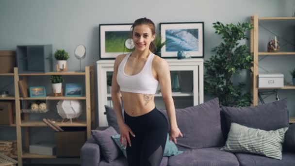 Musculosa joven culturista mirando a la cámara sonriente movimiento ajuste cuerpo fuerte — Vídeos de Stock