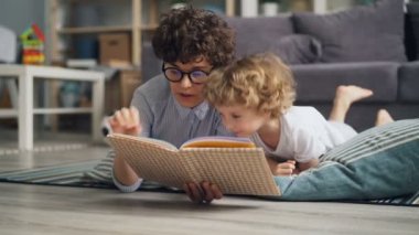 Mutlu aile genç kadın ve küçük çocuk okuma kitabı battaniye var evde yalan