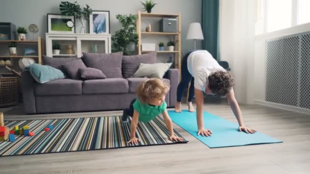 Moeder en zoontje doen yoga samen thuis ontspannen genieten van activiteit — Stockvideo