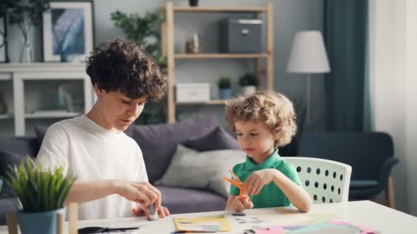 Twórczy dziewczyna i jej dziecko inteligentne Dokonywanie papierze kolaż tworząc piękny design — Wideo stockowe