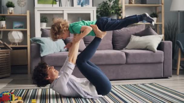 Jonge vrouw met kleine jongen met handen en benen lachen plezier — Stockvideo