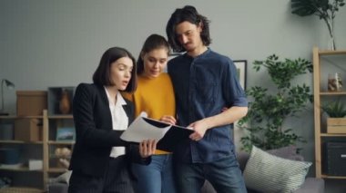 Yeni dairede konut ajanı okuma Sözleşmesi konuşan kız ve adam alıcılar