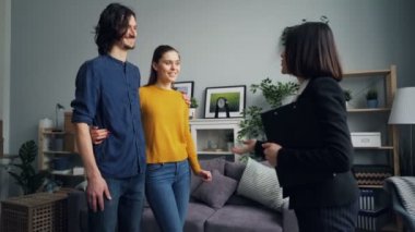 Adam ve kadın ev ajanı öpme ellerini sallayarak konuşurken anahtar alıyor