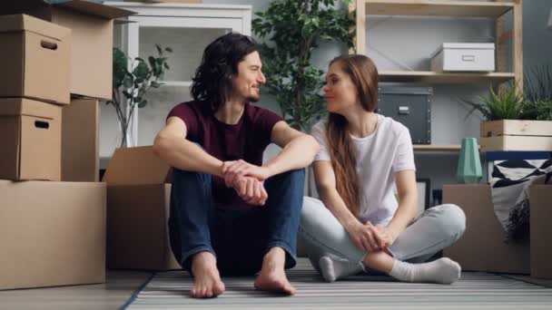 Young man giving keys to girlfriend then kissing relaxing on floor with boxes — Stock Video