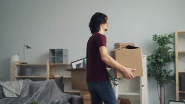 Tipo cansado trayendo cajas pesadas en la habitación que sufren de dolor de espalda durante la reubicación — Vídeo de stock