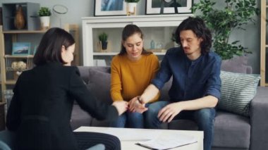 Çift imzalayan kağıt almak anahtar--dan emlakçı öpüşme ve sarılma içinde yeni ev