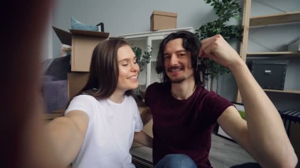 POV di marito e moglie prendere selfie con nuove chiavi piatte baciare e posare — Video Stock