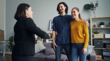 Yeni daire alıcılar anahtarları veren konut ajanı, koca ve karısı öpüşme