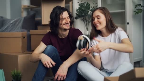 Studenten uitpakken in nieuwe flat te nemen dingen van Box praten tijdens verhuizing — Stockvideo