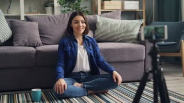 Genç kadın vlogger konuşan işaret kayıt video ile akıllı telefon evde
