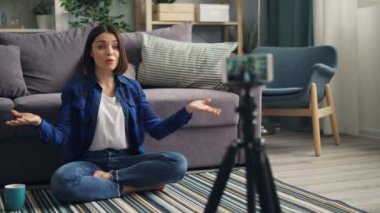 Telefon konuşan ve evde işaret kullanarak kadın vlogger kayıt video