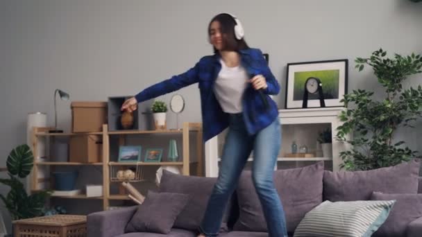 Neşeli kadın şarkı ve evde kulaklıklar müzik dinlerken dans — Stok video