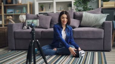 Akıllı telefon kullanarak VR gözlük tutarak gadget hakkında genç bayan kayıt video