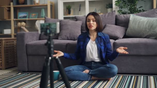 Dívka blogger nahrává video se smartphone mluvící s šálkem doma — Stock video