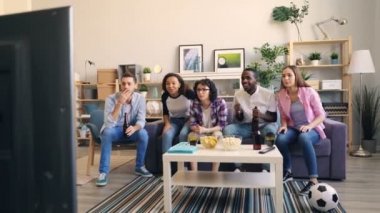 Mutlu genç arkadaşlar tv'de spor izlerken gülerek sarılma yüksek beşyapıyor