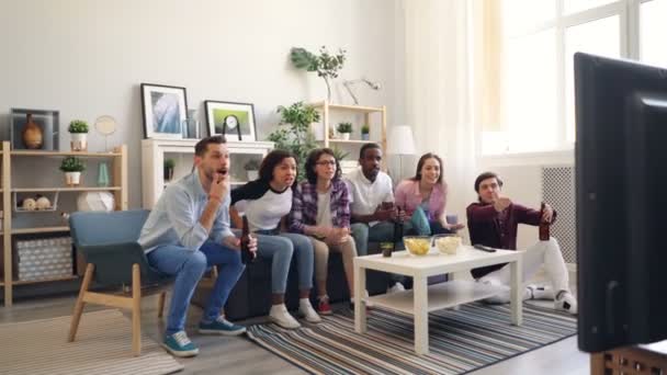 Fãs de esportes assistindo jogo em casa torcendo, em seguida, sentindo-se triste e decepcionado — Vídeo de Stock