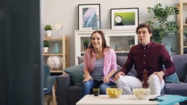 Erkek ve kadın Tv'de spor oyunu sonra sarılma ve gülerek zafer kutluyor