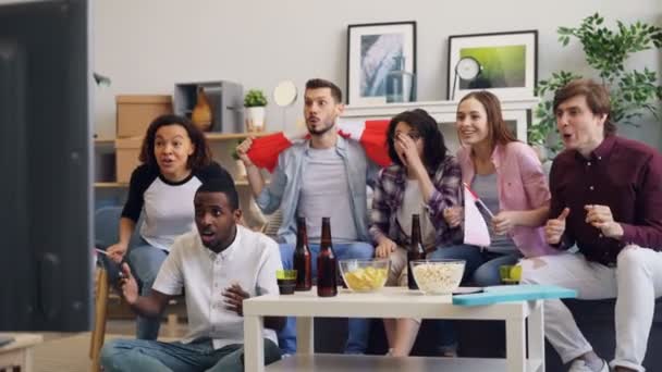 Gelukkige mannen en vrouwen met Canadese vlaggen kijken naar sport op TV vieren overwinning — Stockvideo