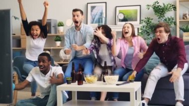 Tv'de spor oyunu sırasında heyecanlı taraftarların sarılma ve yüksek beş yapma yavaş hareket
