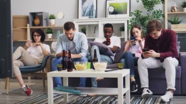 Akıllı telefonları kullanan bir grup genç evde ekrana dokunuyor