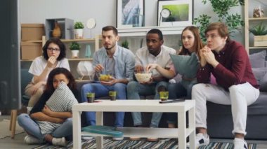 Duygusal arkadaşlar evde Tv'de korkunç korku filmi izlerken ve aperatifler yemek