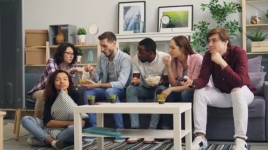 Erkekler ve kadınlar konuşurken ve gülümseyerek sonra Tv'de trajik haber izlerken dehşete