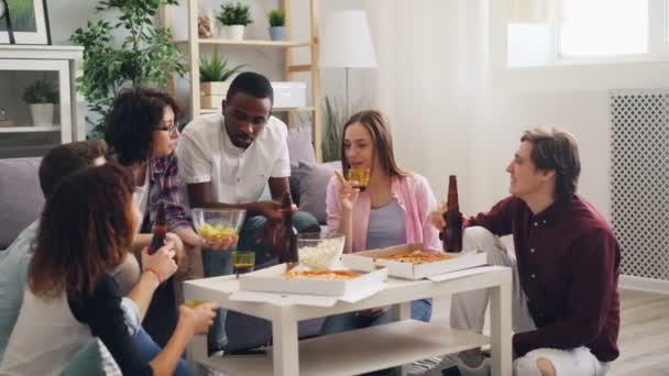 Hombres y mujeres hablando comiendo y bebiendo vasos colgantes en la fiesta de la casa — Vídeos de Stock