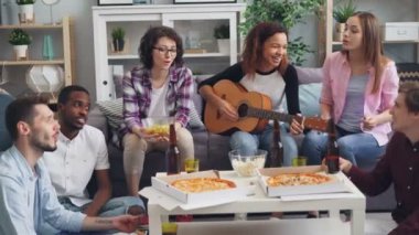 Mutlu arkadaşlar gitar çalmak ve dairede partide bira içme şarkı