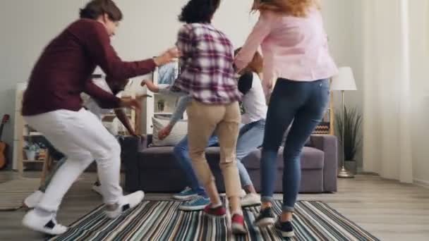 Pomalý pohyb studentů, kteří utíkaně sedí na pohovce a dívají se na kameru — Stock video