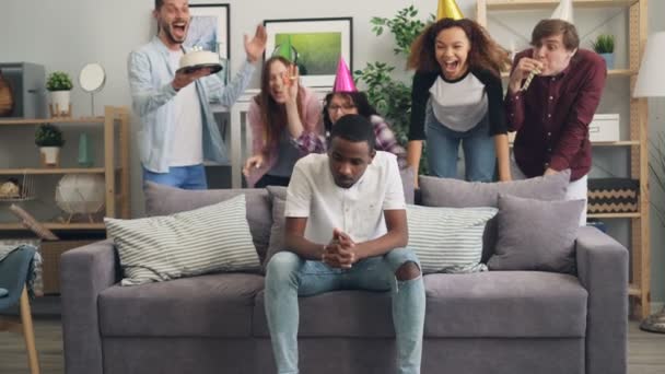 Amigos fazendo surpresa trazendo bolo no aniversário para o cara afro-americano triste — Vídeo de Stock