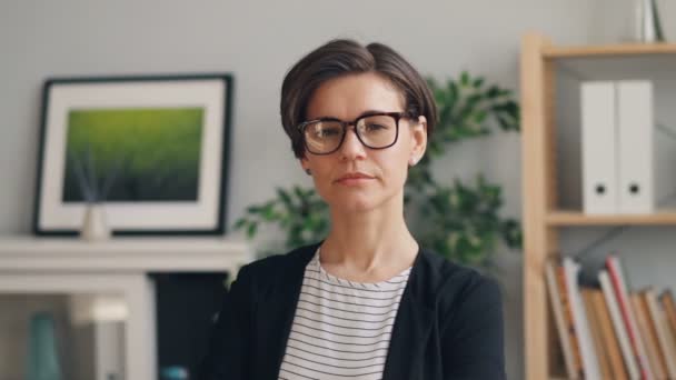 Portret van jonge aantrekkelijke zakenvrouw staand in kantoor kijken naar camera — Stockvideo