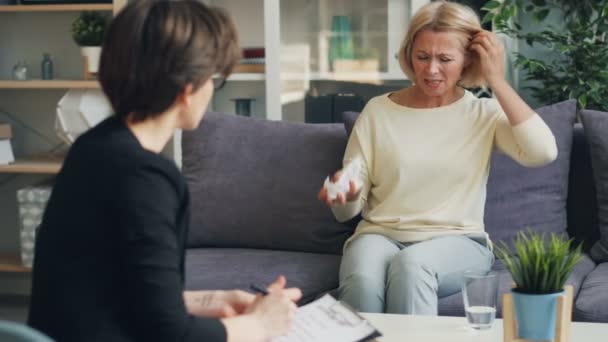 Несчастная зрелая леди обсуждает проблемы с женщиной-психологом в уютном офисе — стоковое видео