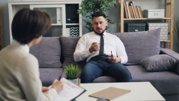 Malheureux homme d'âge moyen discuter des problèmes avec le psychologue au bureau — Video