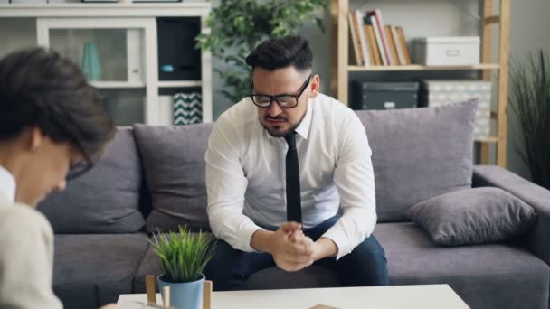 Gloomy middle-aged man sharing problems with therapist during private session — Stock Video