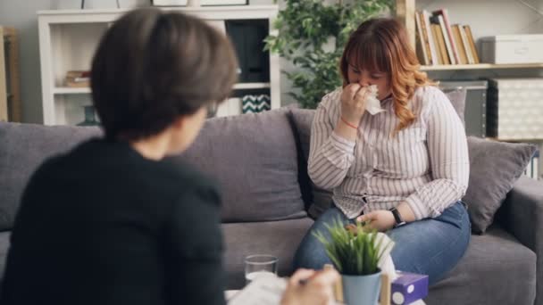 Depressive junge fettleibige Frau weint im Gespräch mit Psychotherapeut im Büro — Stockvideo