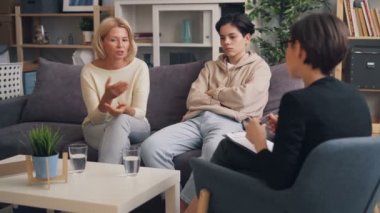 Anne ve genç oğlu ofiste psikoterapist ile istişare olan
