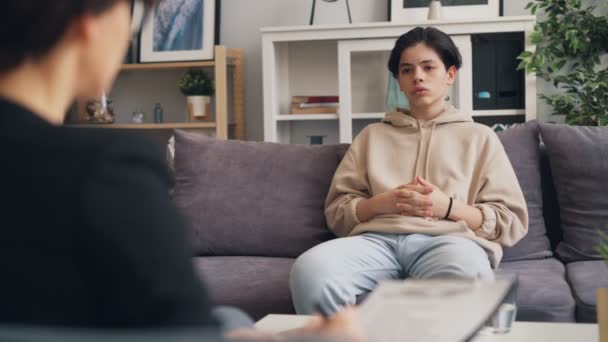 Adolescent déprimé ayant une conversation avec un psychothérapeute dans un bureau moderne — Video