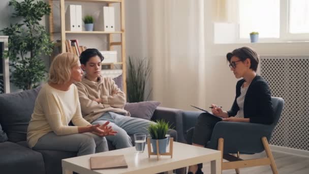 Unruhiger Teenager besucht Therapeut mit Mutter, Frau spricht und fragt Rat — Stockvideo