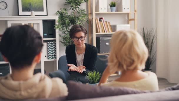 Опытный психолог консультирует мать и подростка в офисе — стоковое видео