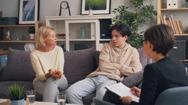 Женщина и подросток обсуждают отношения матери и сына с психотерапевтом — стоковое видео