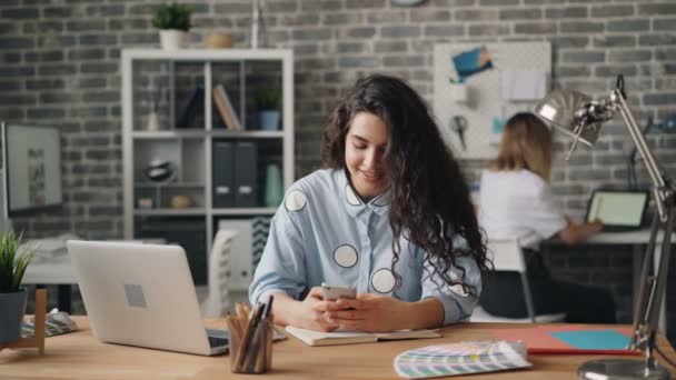 Vrolijk meisje met behulp van smartphone aanraken scherm werken in Office op Bureau — Stockvideo