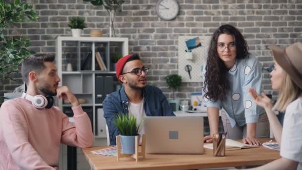 Équipe créative parlant au bureau discutant des idées regardant l'écran d'ordinateur portable — Video